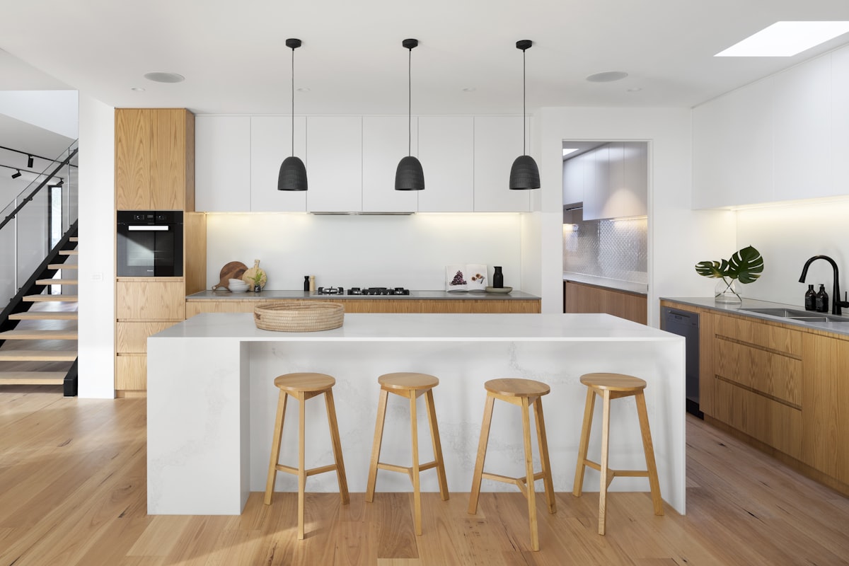 A modern kitchen with white cabinets and quartz countertop island -- the kind of mid-range remodel most NJ homeowners aim for (Photo: R Architecture / Unsplash)