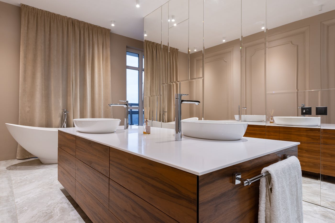 Luxury modern bathroom with a double floating vanity, vessel sinks, and a freestanding tub