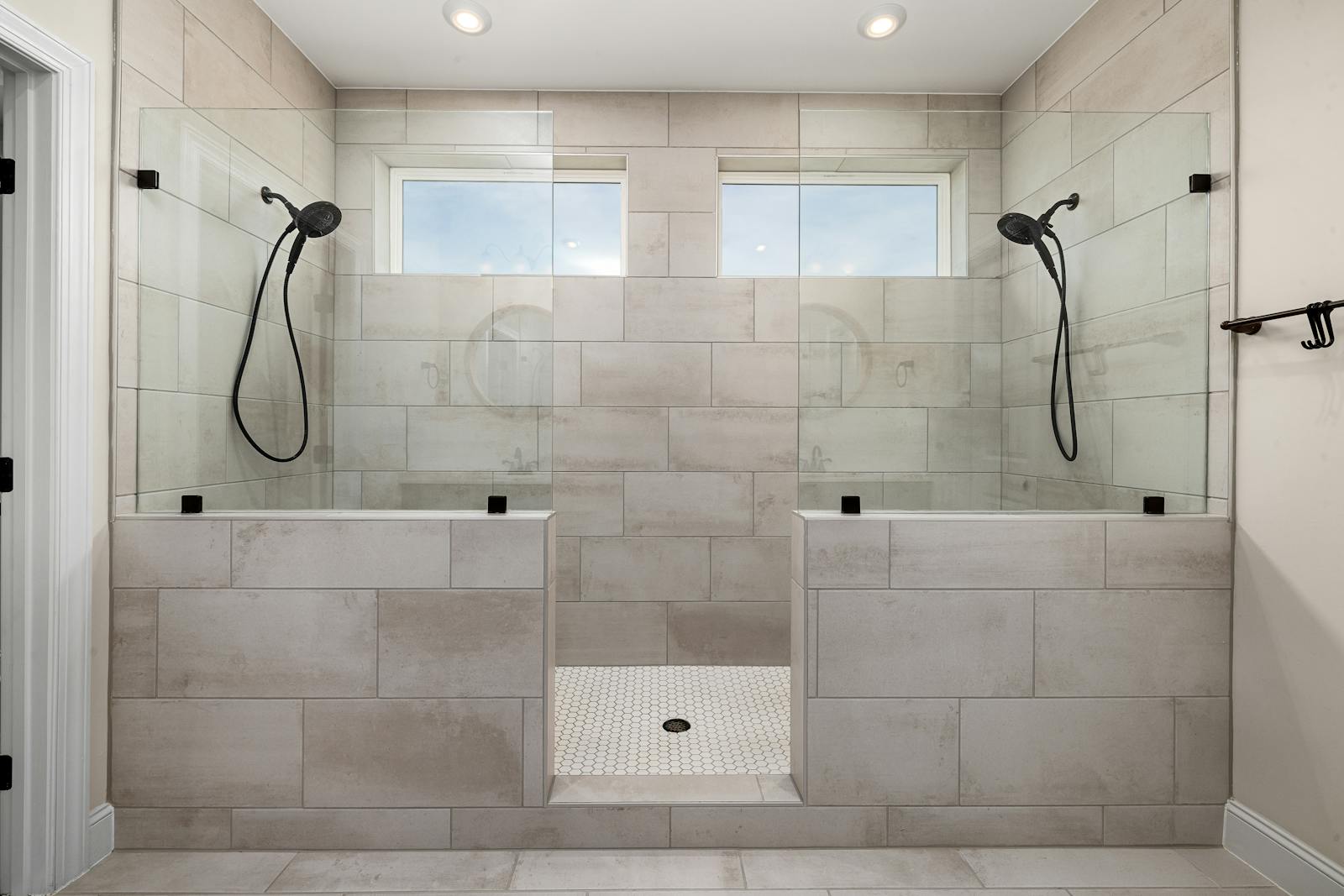 A modern tiled walk-in shower with a frameless glass enclosure — the upgrade that makes a mid-to-high-end NJ bathroom feel custom