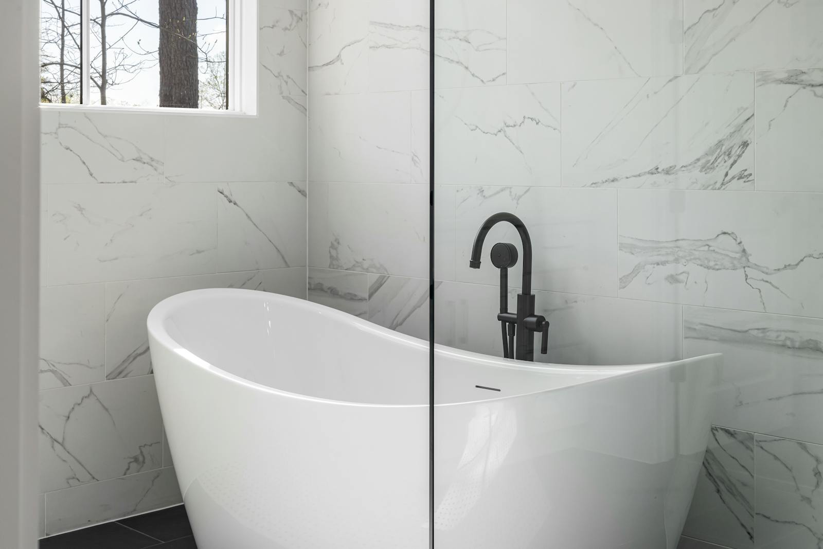 A modern bathroom built around a freestanding soaking tub — the sculptural centerpiece a freestanding tub creates