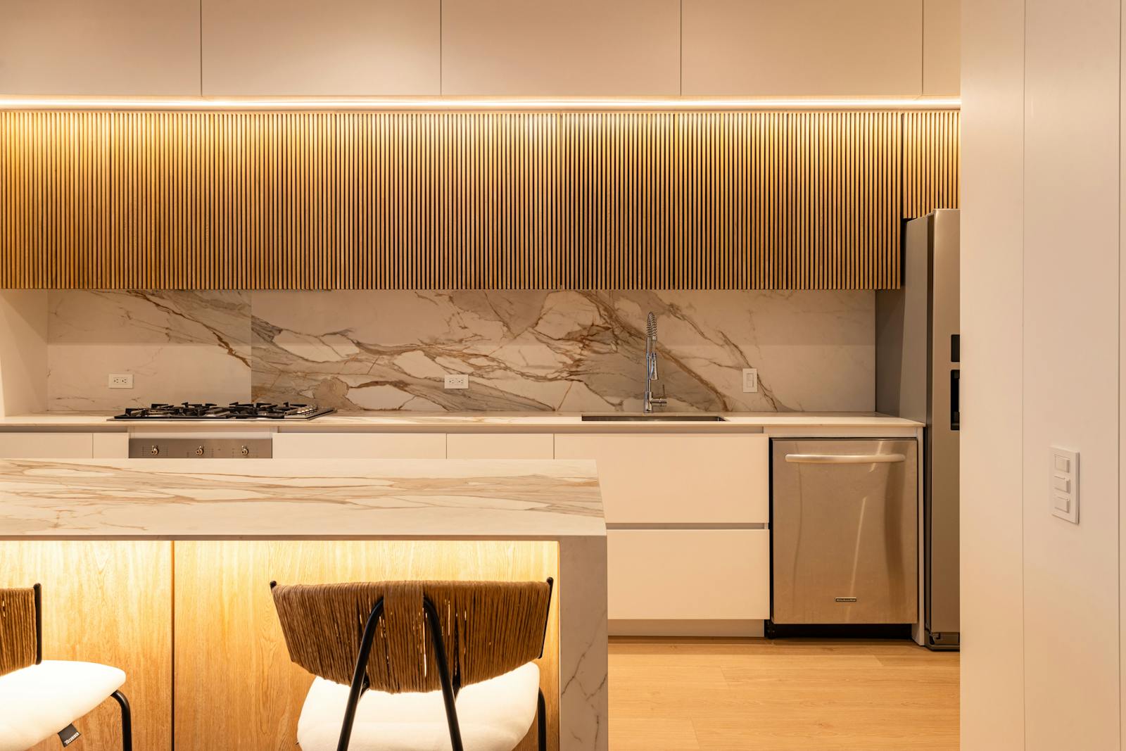 A sleek, modern kitchen with a light stone-look counter — porcelain's thin, large-format slabs deliver this seamless, contemporary look