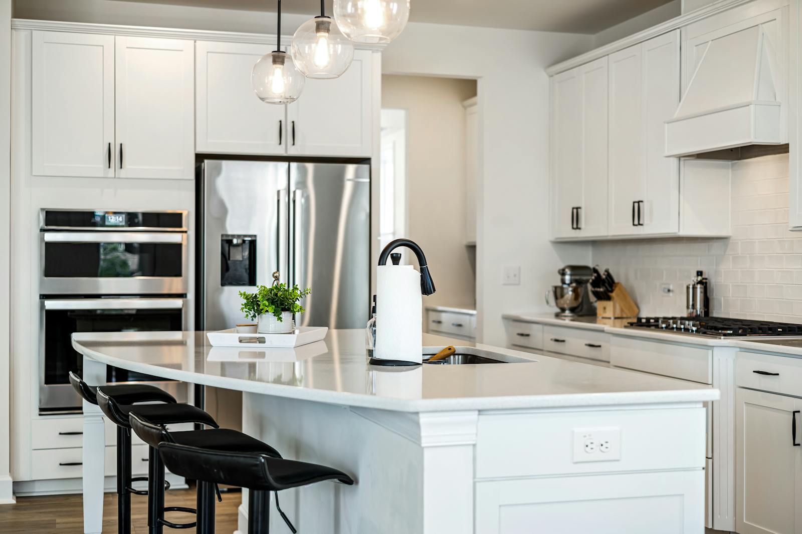 Modern white kitchen with a large quartz island — quartz is the top material for a seamless, chip-resistant waterfall edge